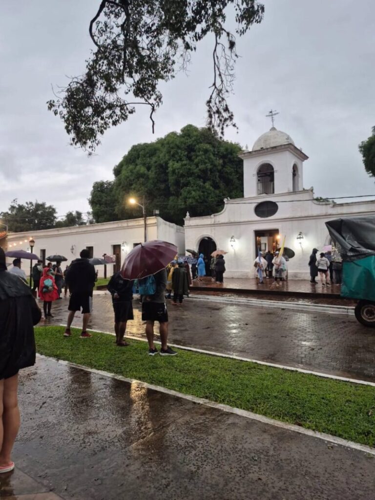 Peregrinos caminando bajo la lluvia al inicio de la 126ª Peregrinación de los Tres Pueblos en Corrientes.